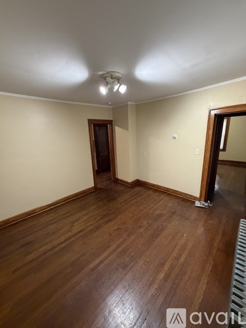 A room with wooden floors and a ceiling light.