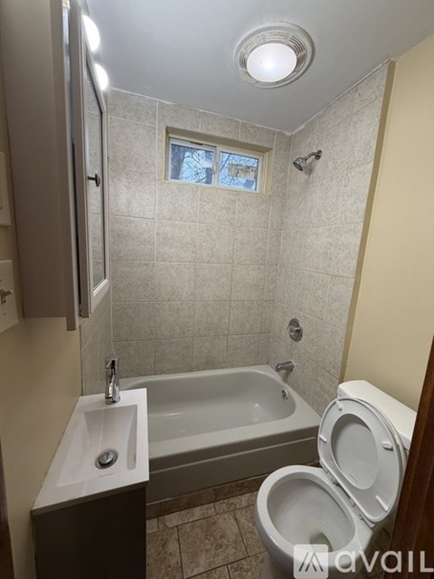 A bathroom with a toilet, sink, and bathtub.