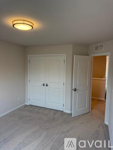 A bedroom with a carpeted floor and a white door.