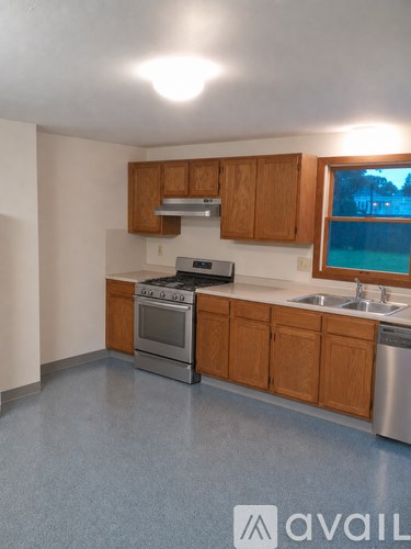A kitchen with wooden cabinets and a window.