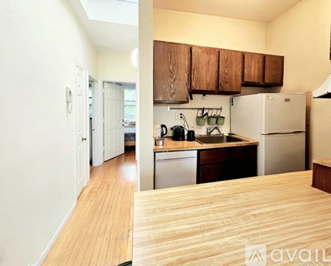 A kitchen with wooden cabinets and a white refrigerator.