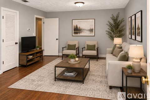 A living room with a couch, chairs, and a coffee table.