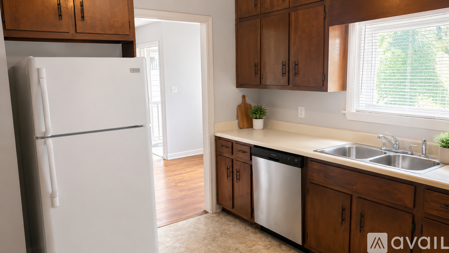 A kitchen with a white fridge and wooden cabinets.