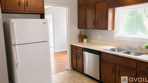 A kitchen with a white fridge and wooden cabinets.