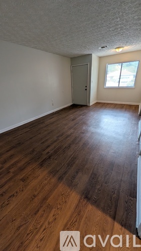 A room with wooden flooring and a door.