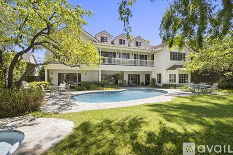 A large white house with a pool in the backyard.