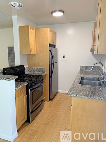 A kitchen with wooden cabinets and a granite countertop.