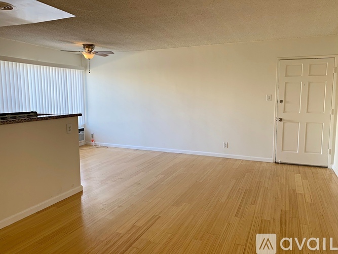 A room with wooden flooring and a white door.