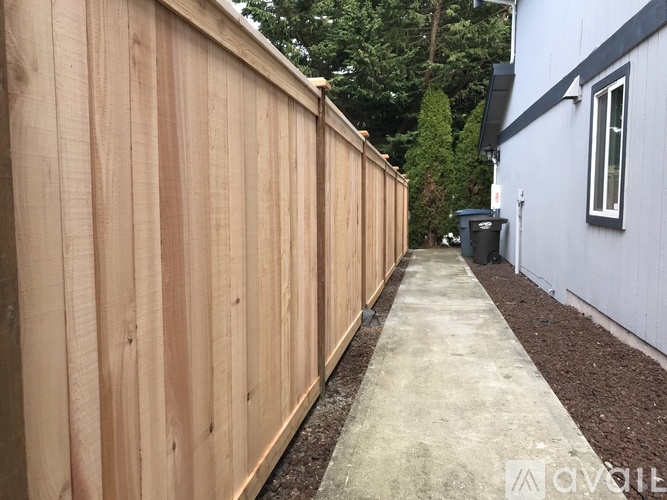 A wooden fence runs along the side of a building.