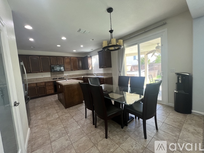 A kitchen with a dining table and chairs.