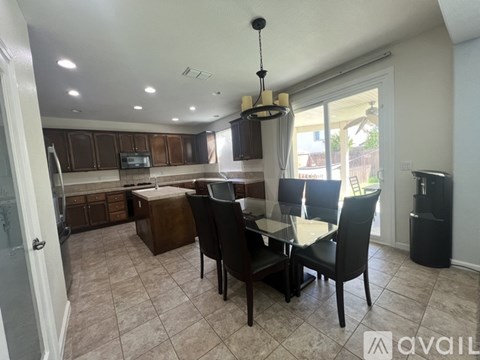 A kitchen with a dining table and chairs.