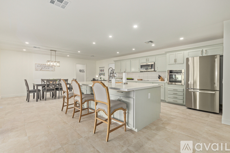 A kitchen with a dining table and chairs.