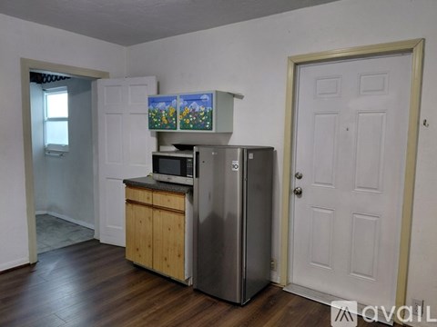 A kitchen with a fridge, microwave, and stove top oven.