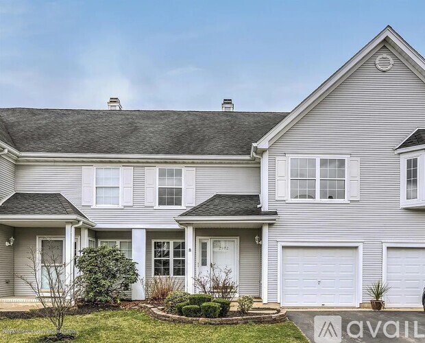 A house with a grey exterior and white trim is available for sale.