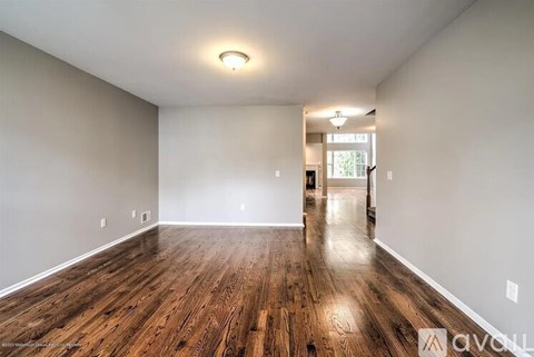 A spacious room with wooden floors and white walls.