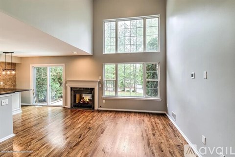 A spacious living room with a fireplace and large windows.