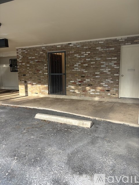 A room with a brick wall and a white door.