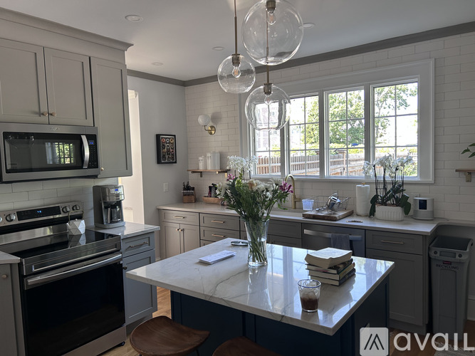 A kitchen with a white table and a stove top oven.