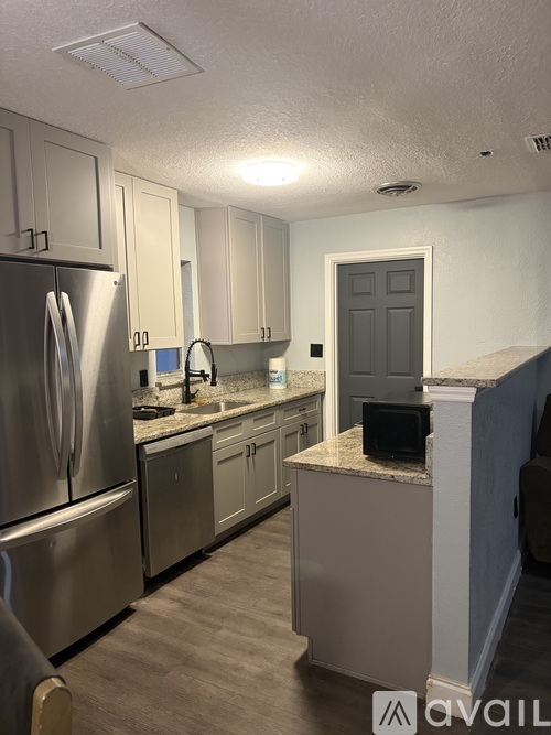 A kitchen with a stainless steel refrigerator and a sink.