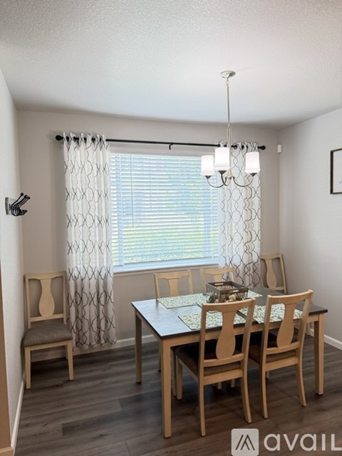 A dining room with a table and chairs.