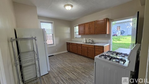 A kitchen with a refrigerator, cabinets, and a stove top oven.