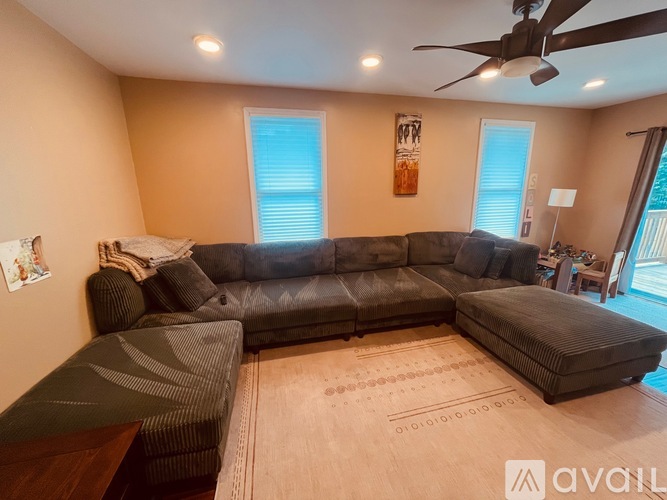 A living room with a large sectional sofa and a rug.