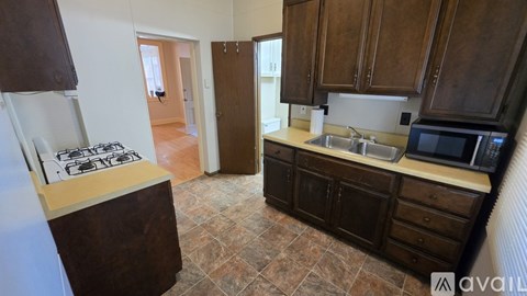 A kitchen with brown cabinets and a tiled floor.