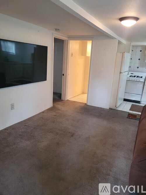 A living room with a flat screen TV mounted on the wall.