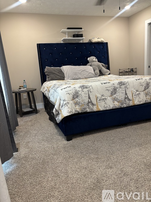 A bedroom with a bed and a teddy bear on it.
