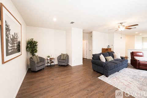 A living room with a grey couch, a chair and a small table.