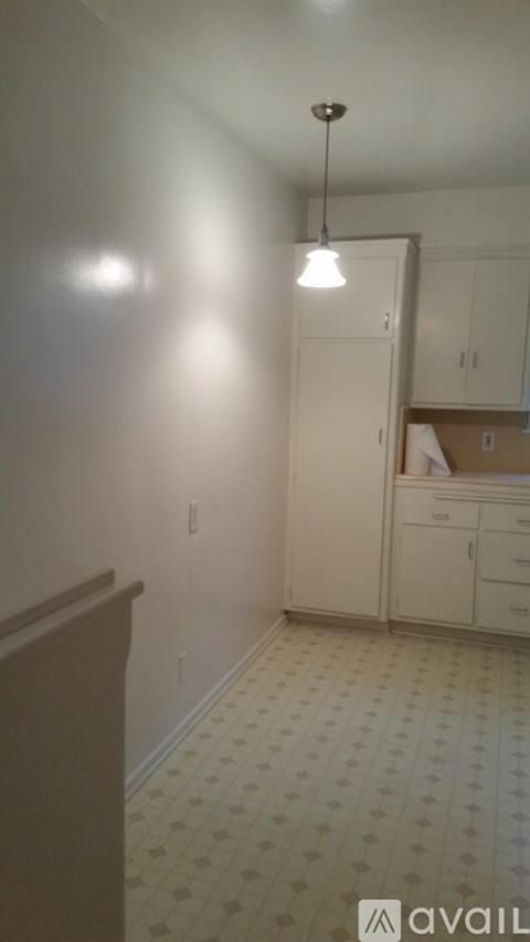 A kitchen with white cabinets and a tiled floor.
