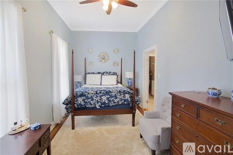 A bedroom with a four poster bed and a ceiling fan.