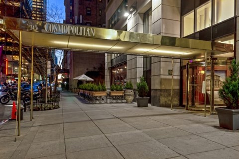 The entrance to the Cosmopolitan building is shown at night.