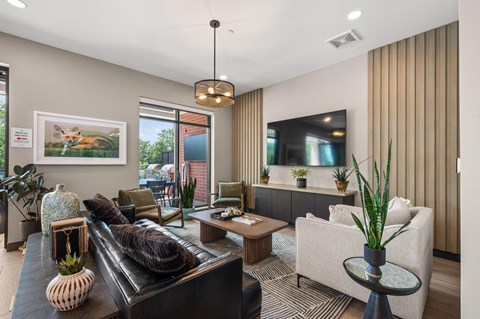 A living room with a black couch and a white chair.