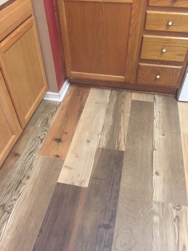A kitchen with wooden floors and cabinets.