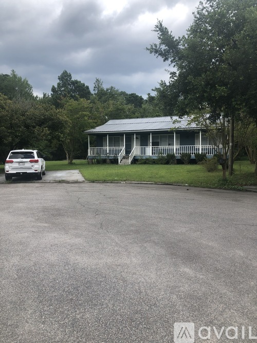 A car is parked in a driveway in front of a house.