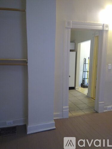 A hallway with a white door and a white wall.