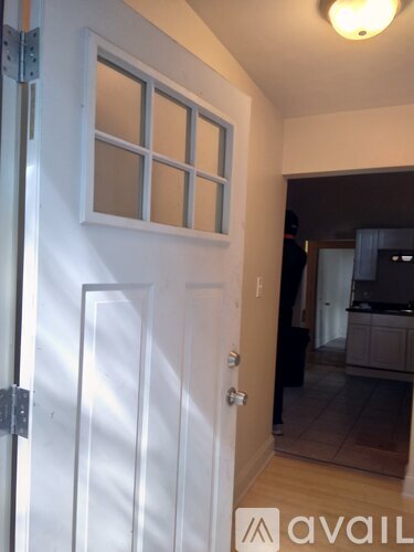 A white door with a glass window is open.