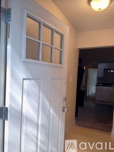 A white door with a glass window is open.