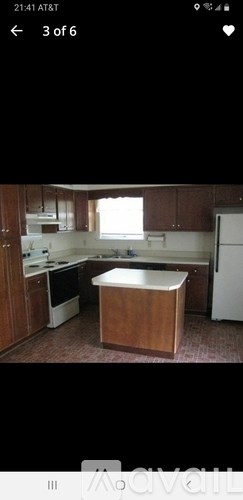 A kitchen with brown cabinets and a white refrigerator.