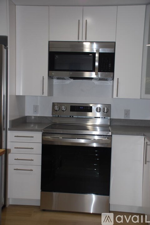 A modern kitchen with white cabinets and stainless steel appliances.