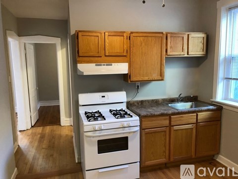 A kitchen with wooden cabinets and a white stove top oven.