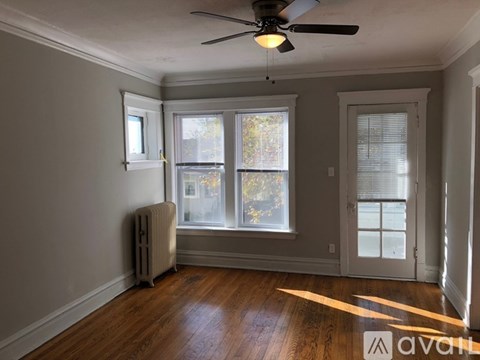 A room with a ceiling fan and a window with blinds.