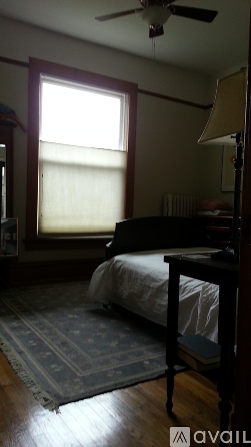 A bedroom with a bed, a ceiling fan, and a rug.