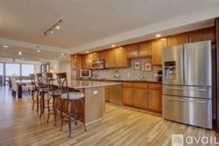A kitchen with wooden cabinets and a stainless steel refrigerator.