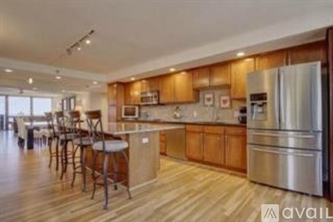 A kitchen with wooden cabinets and a stainless steel refrigerator.
