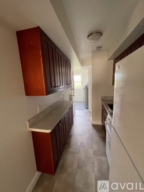A kitchen with brown cabinets and a tiled floor.