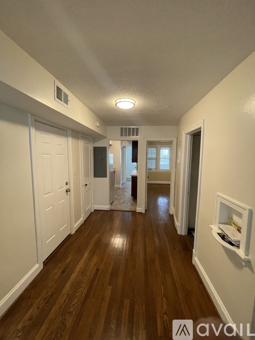 A hallway with wood floors and white walls.