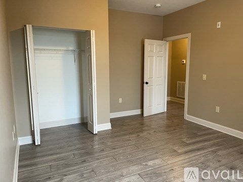 A room with a white door and a white fridge in it.