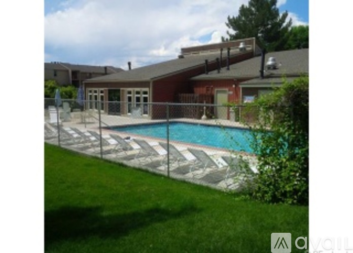 A pool surrounded by a black fence and a green lawn.